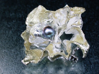 Broche zilver ,met gepatineerd  goud afbeelding arnhem met grijzen parel.